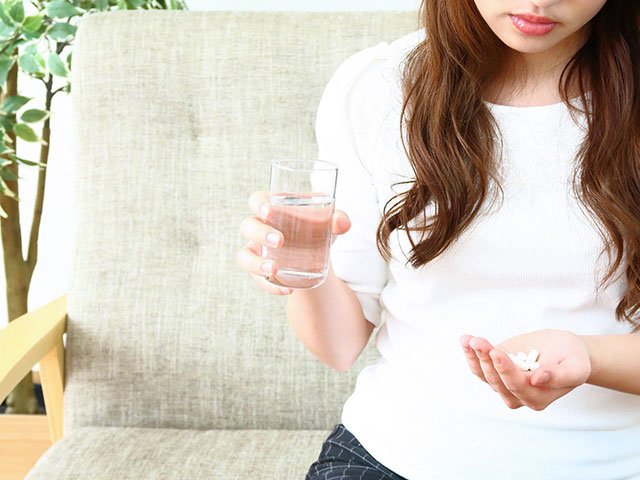薬を飲む女性