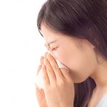 鼻をかんでいる女性