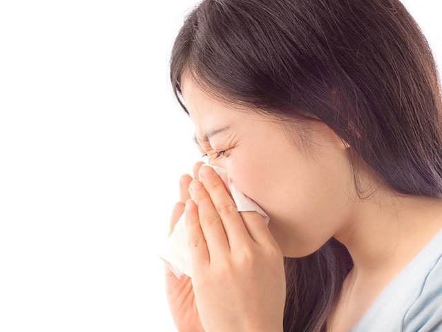 鼻をかんでいる女性